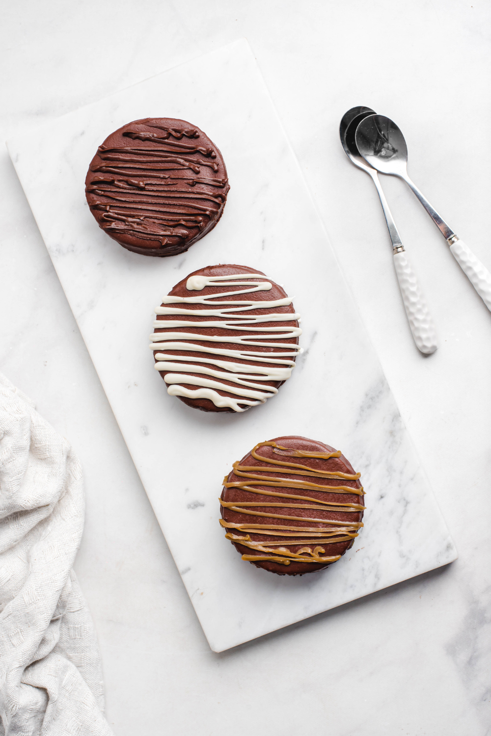 Tres alfajores distintos sobre un plato.