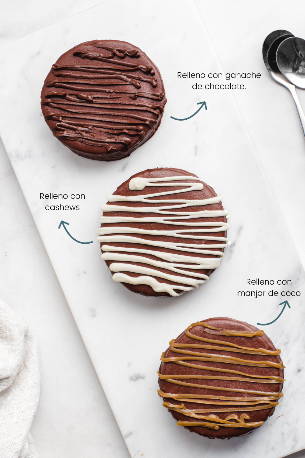 Tres alfajores distintos sobre un plato. Textos sobreimpresos señalan qué tipo de alfajor son cada uno. El de arriba es uno relleno con ganache de chocolate, el del medio es un relleno con cashews, y el de abajo es uno relleno con manjar de coco.