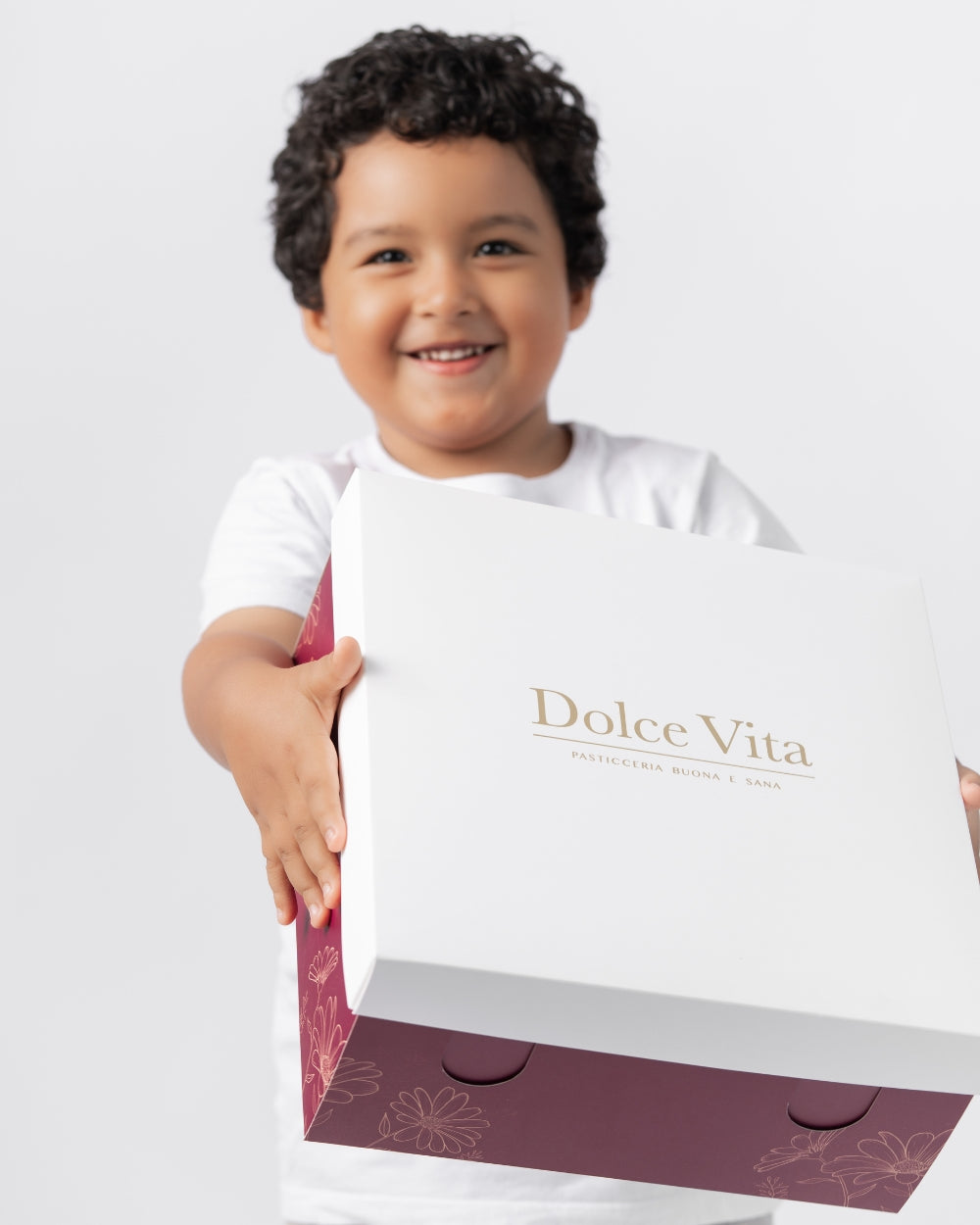 Un niño sostiene una caja de Dolce Vita.