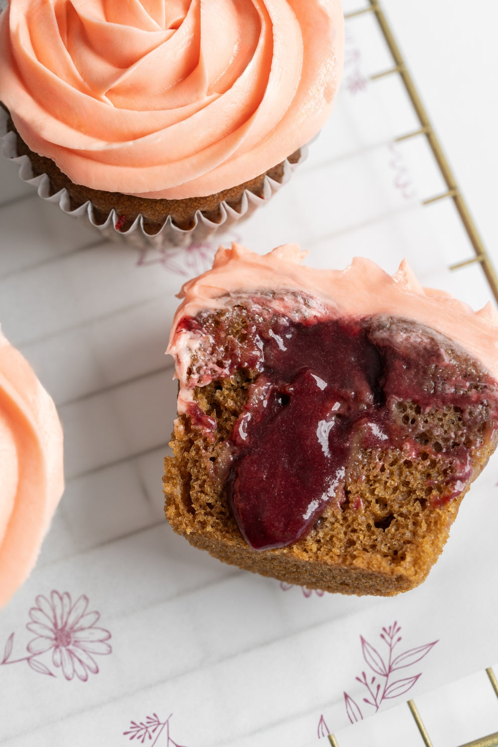 Un cupcake de vainilla partido a la mitad. El centro líquido se chorrea.