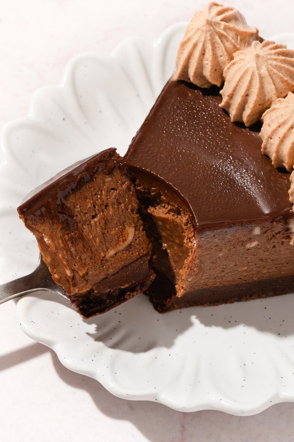 Un trozo de cheesecake de chocolate sobre un plato.