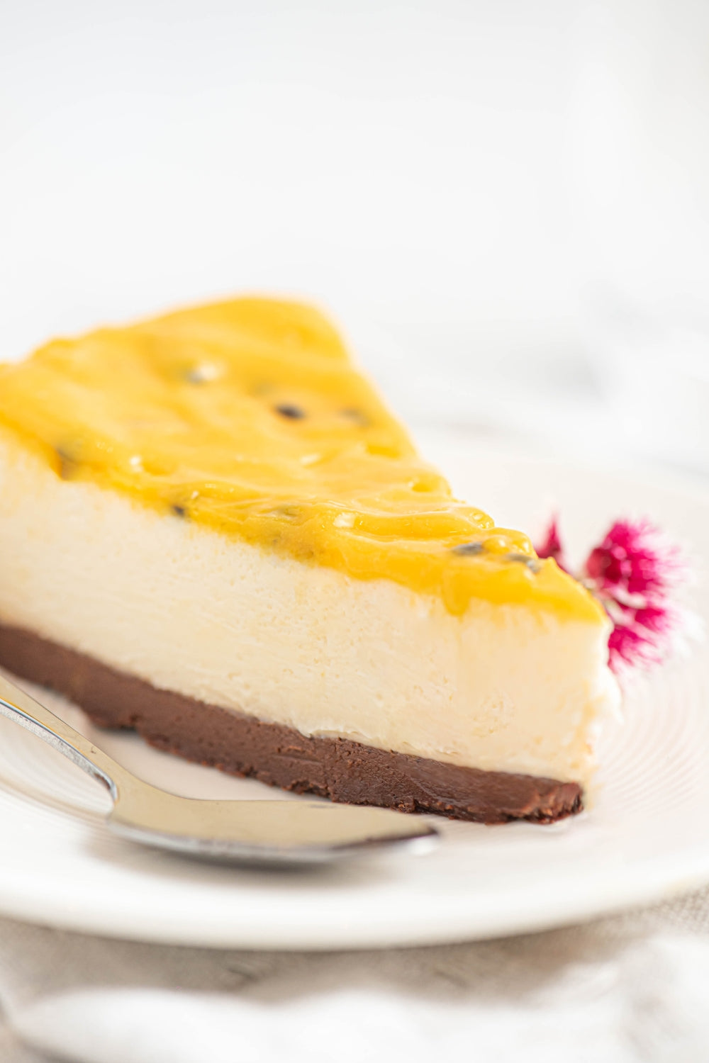 Un trozo de cheesecake de maracuya sobre un plato.