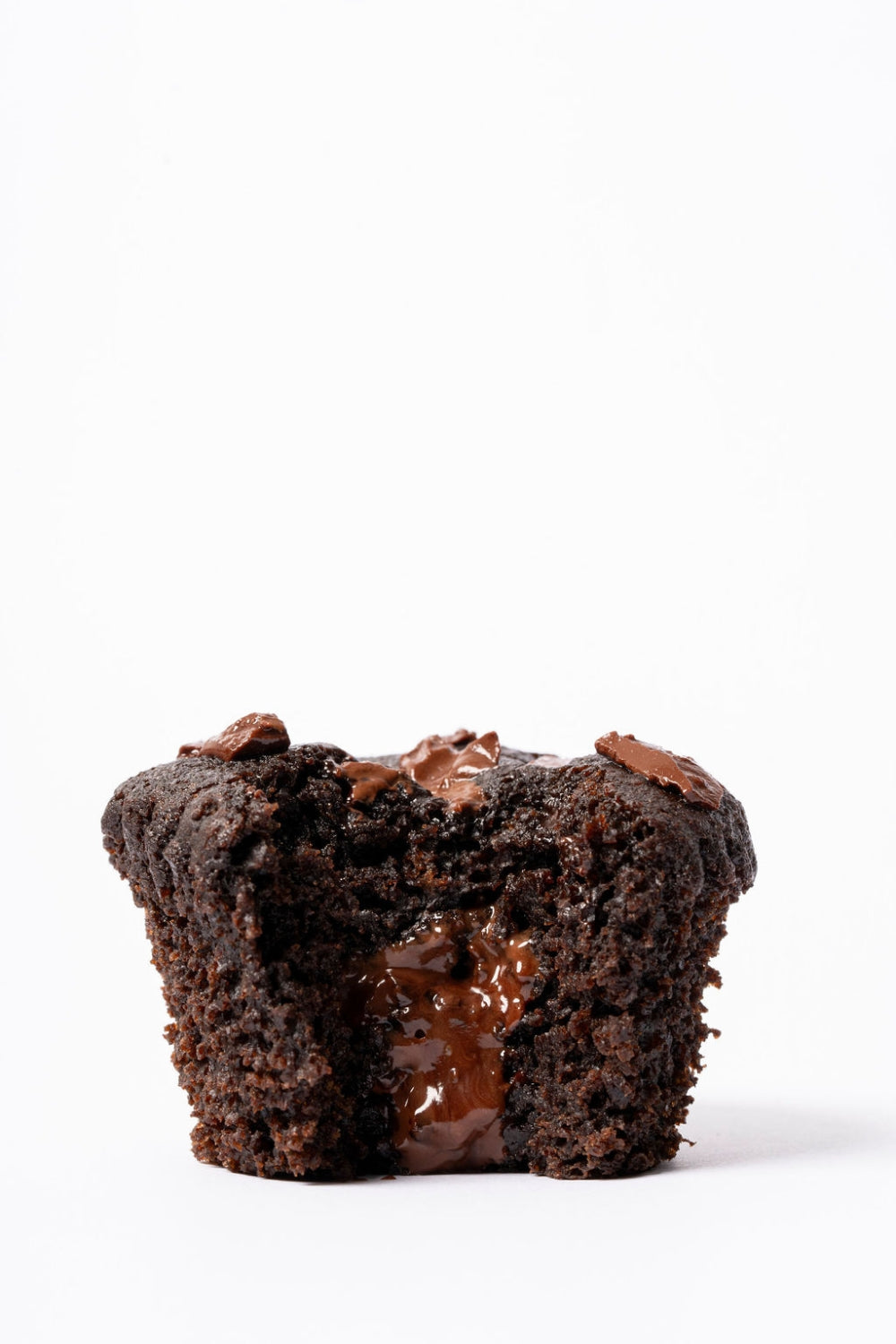 Muffin de doble chocolate partido a la mitad. El centro líquido se chorrea.