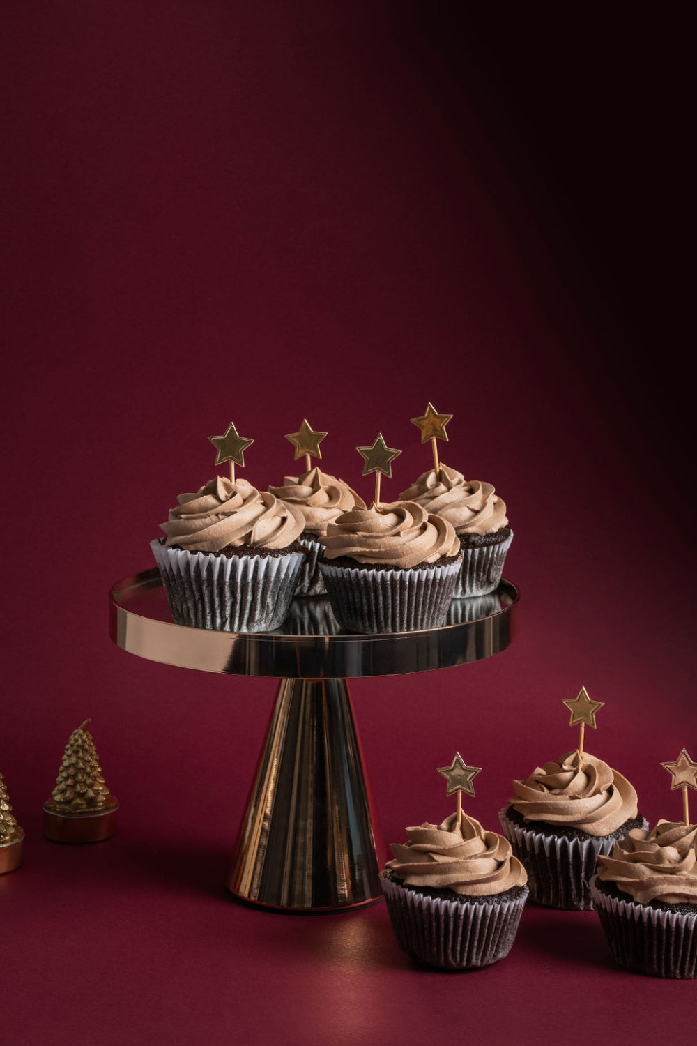 Un parante con cuatro cupcakes de chocolate. A su lado se encuentran tres cupcakes más.