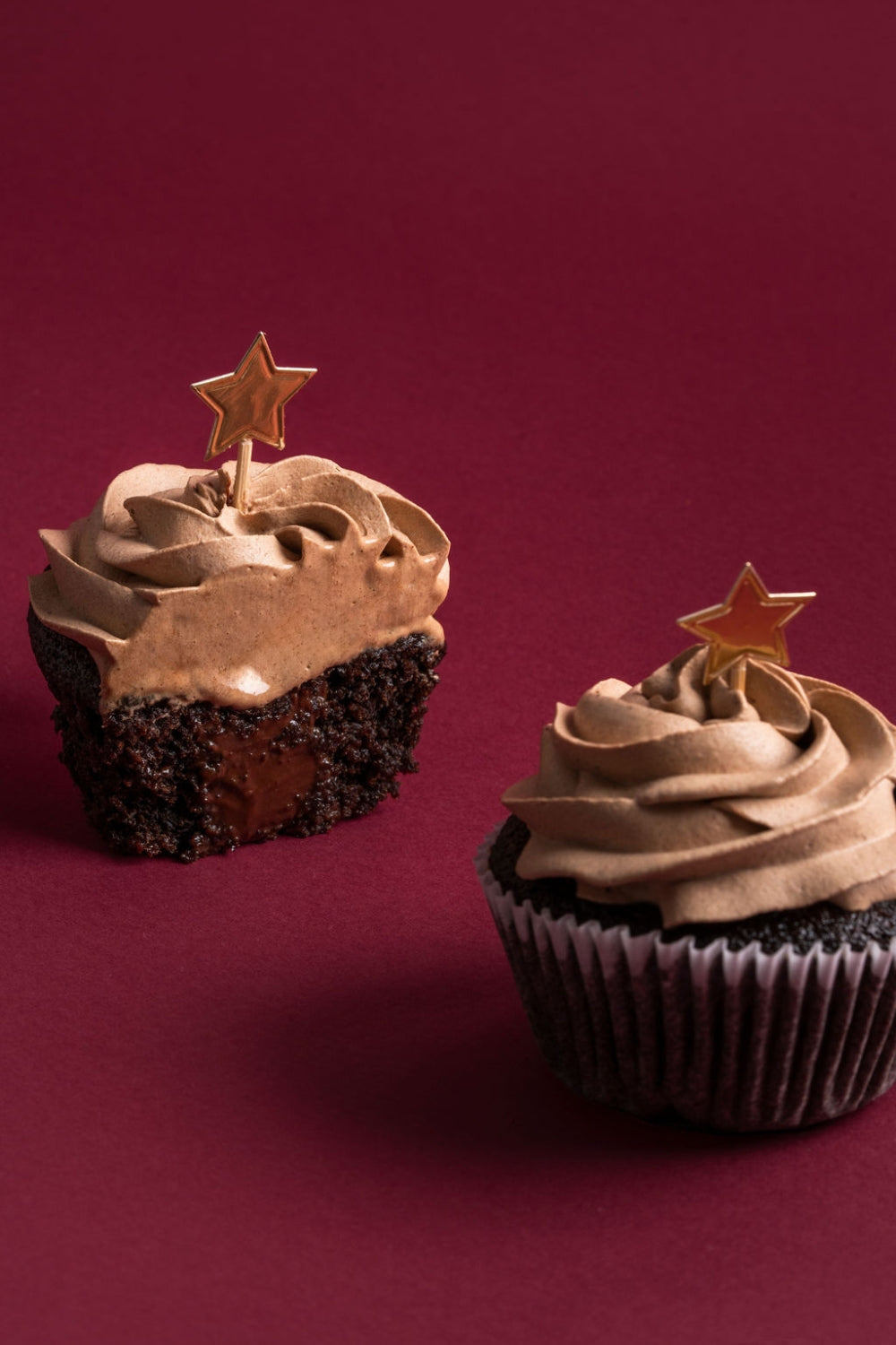 Dos cupcakes de chocolate. Uno está entero y el otro esta partido por la mitad.