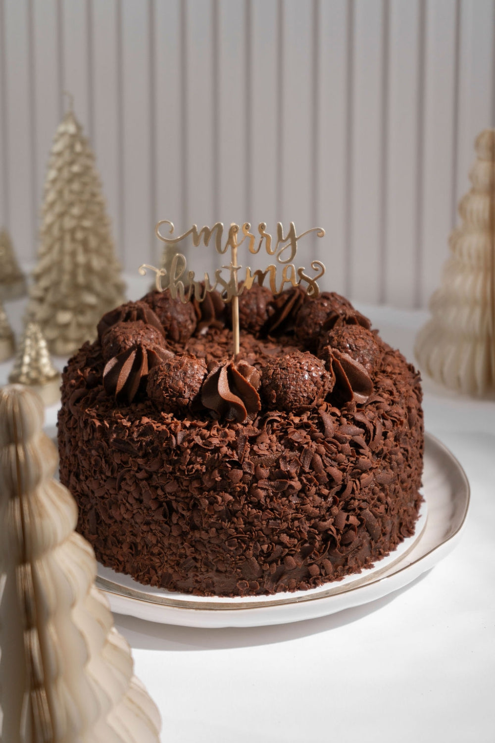 Totra de chocolate con un topper que dice "merry christmas".