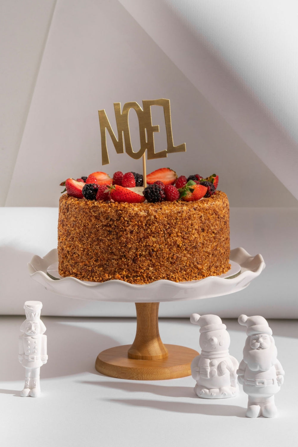 Torta de zanahoria sobre un parante. Sobre la torta hay un topper que dice "Noel".