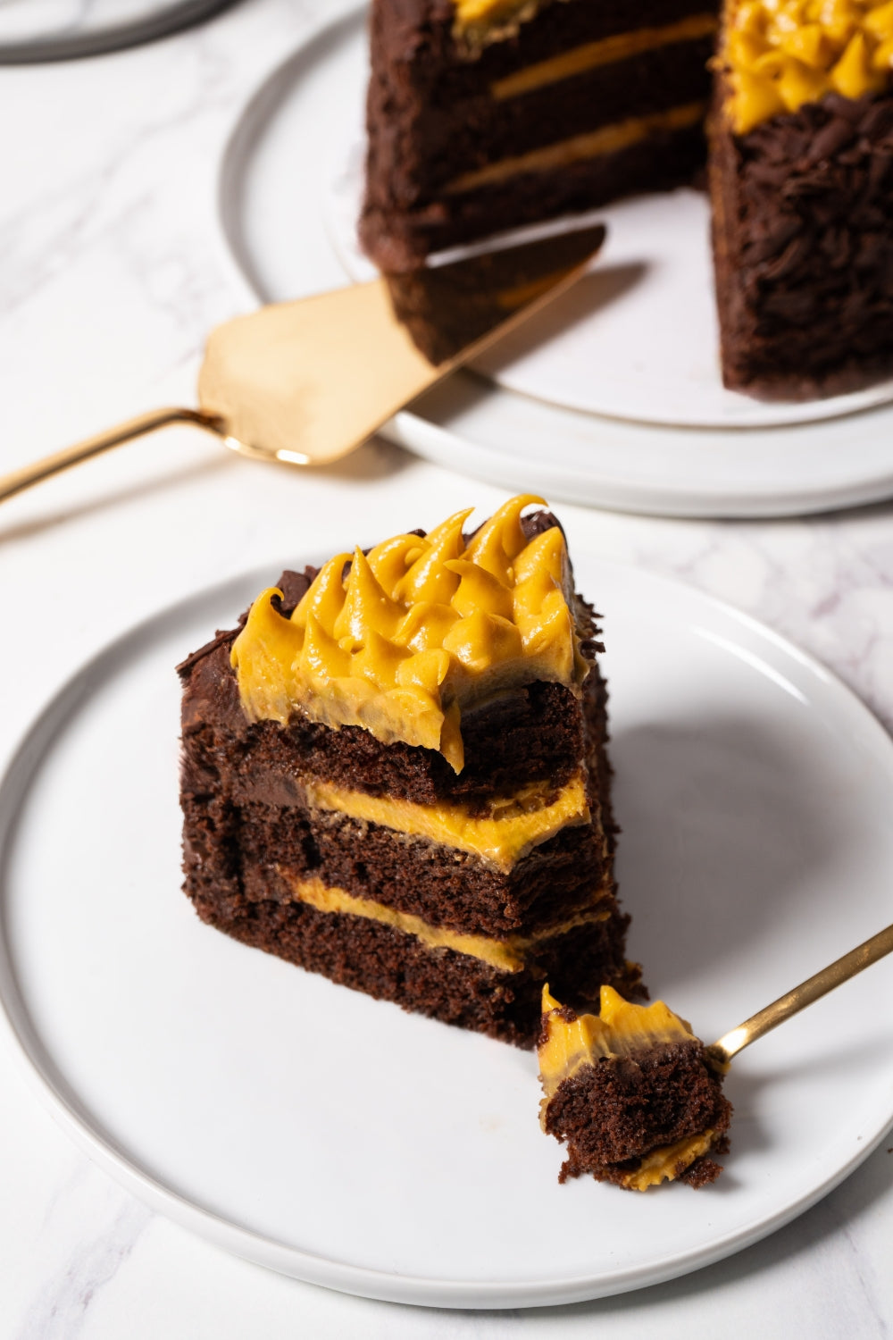 Un trozo de torta de chocolate y lúcuma sobre un plato.
