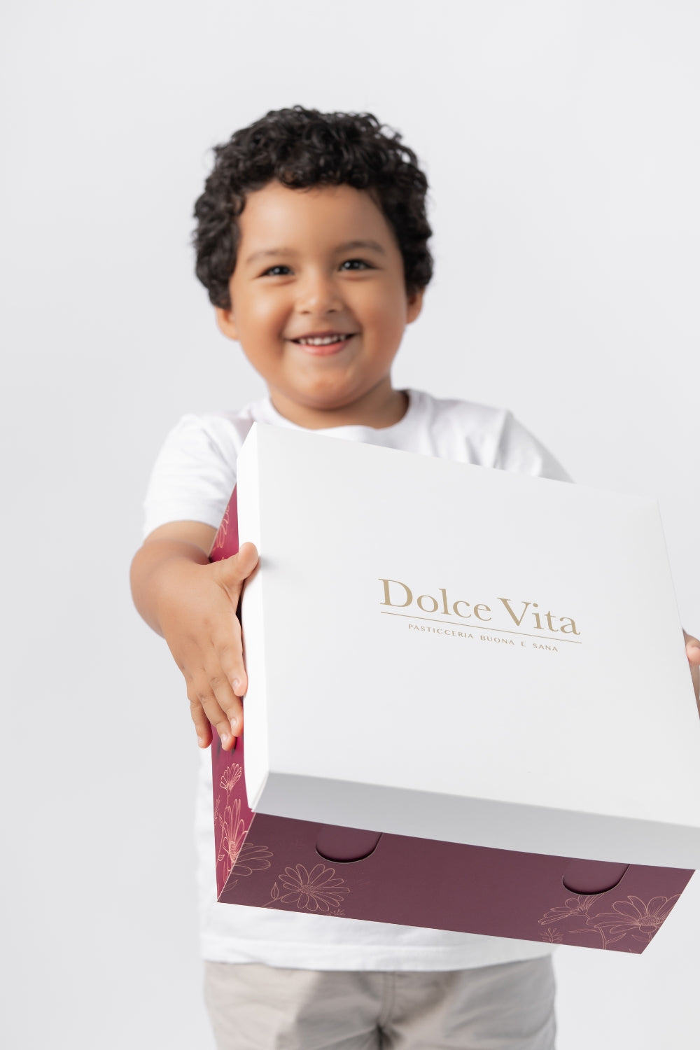 Un niño sostiene una caja de Dolce Vita.