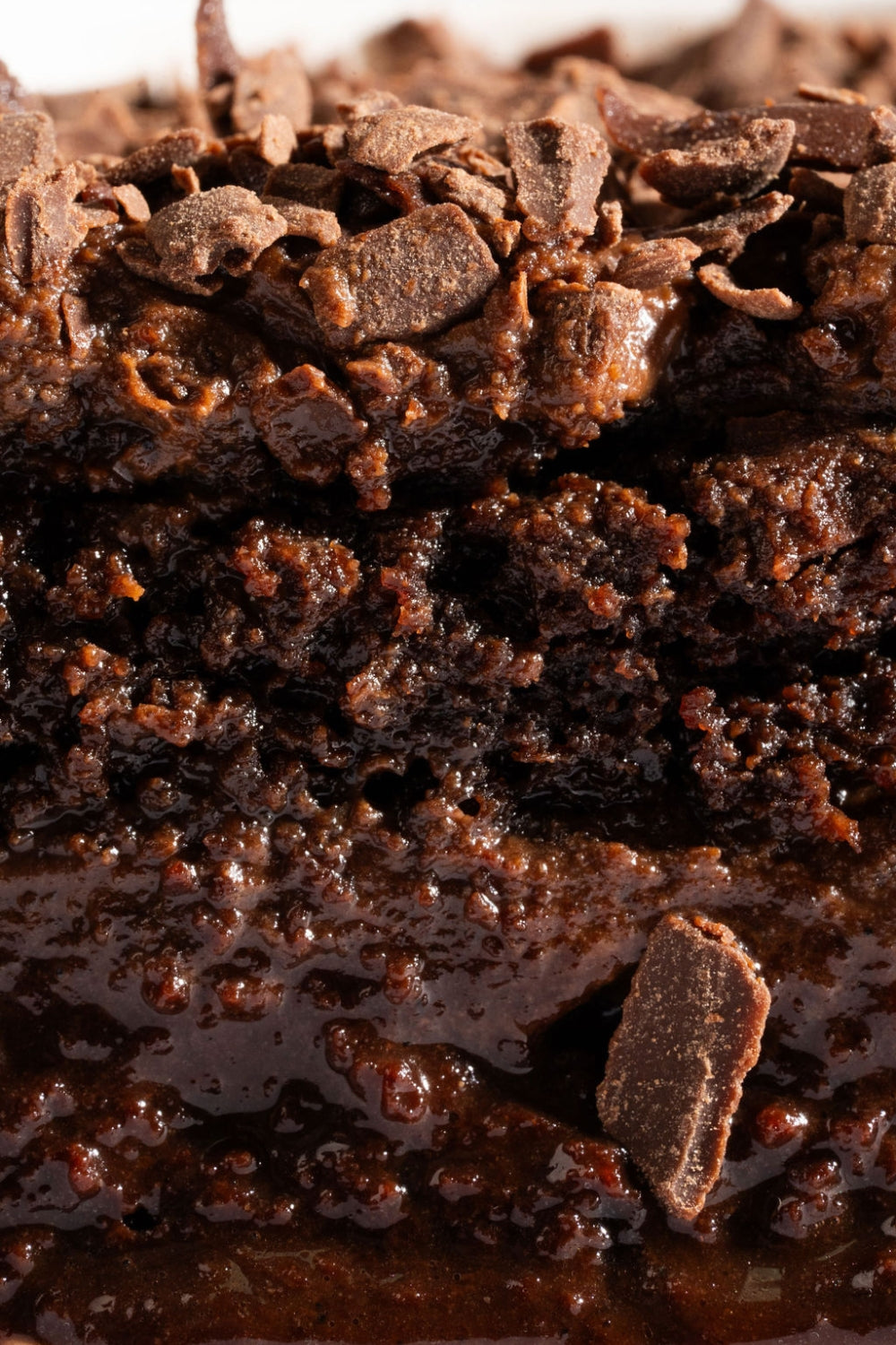 Una cuchara sostiene un pedazo de torta de chocolate.  