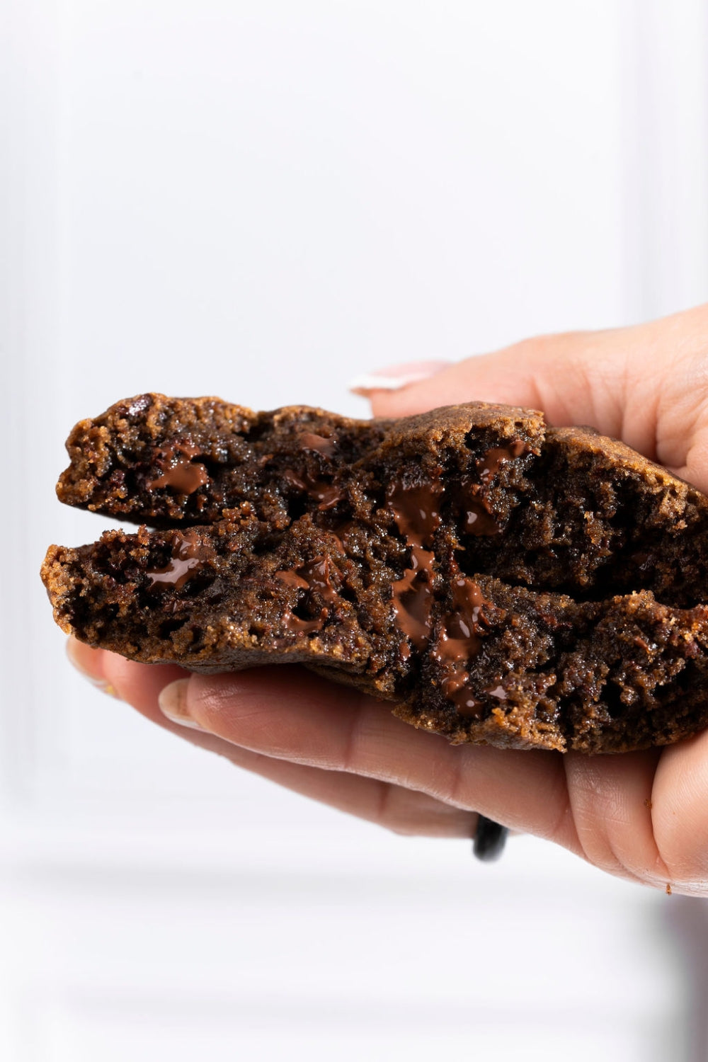 Una mano sujetando una galleta partida a la mitad. 
