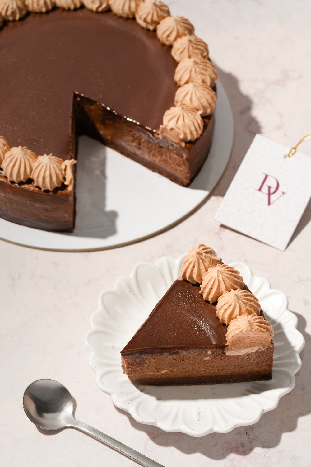 Un cheesecake y a su lado un plato sostiene un trozo que fue retirado del postre. 