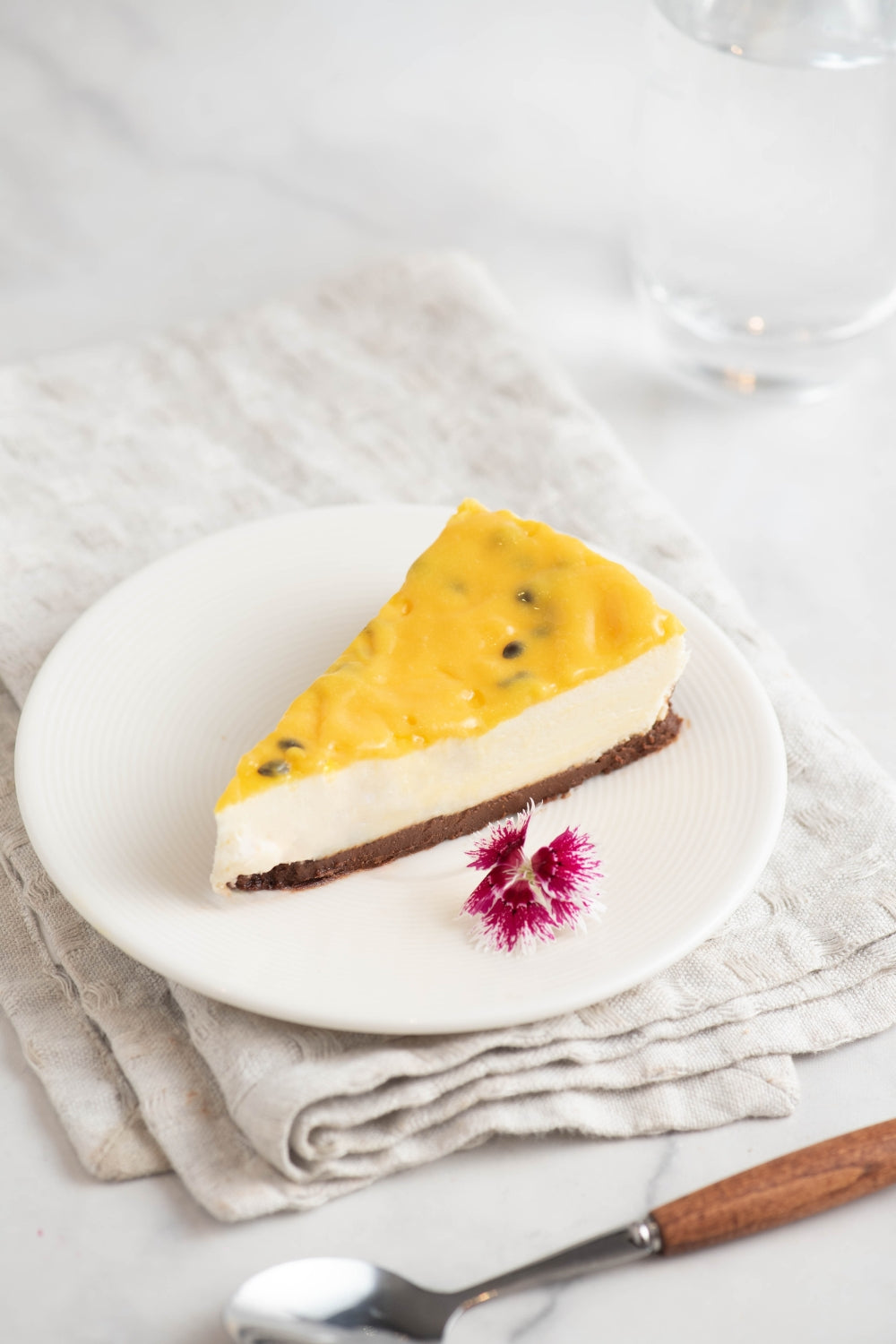 Un trozo de cheesecake de maracuya sobre un plato. 