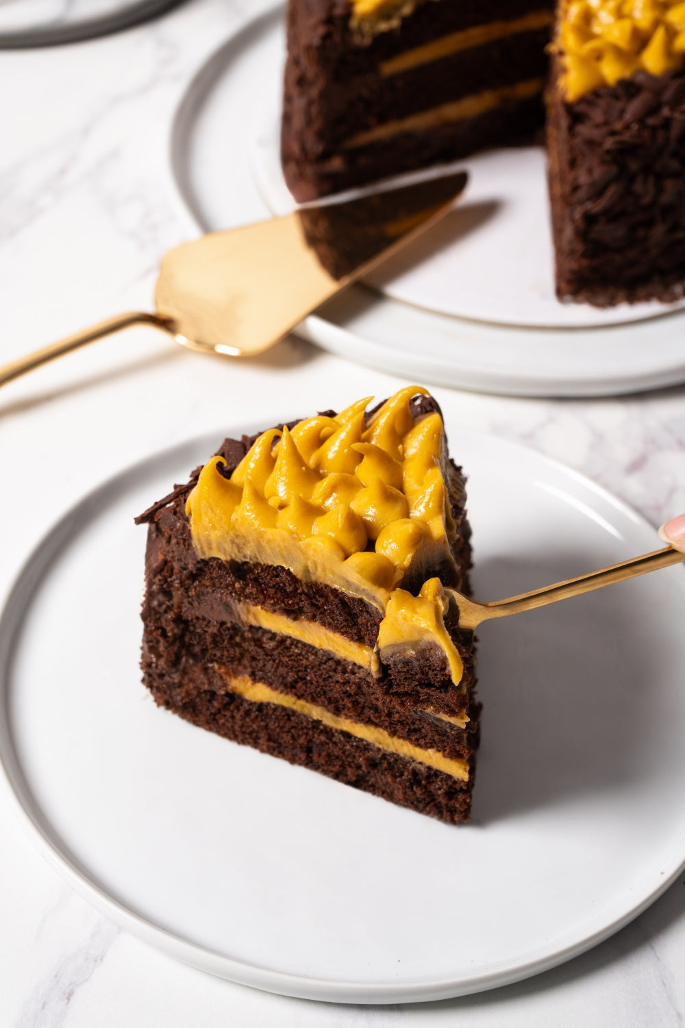 Un trozo de torta de chocolate y lúcuma sobre un plato.